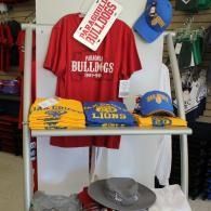 Football fan apparel display with red, white, and blue shirts and hats on shelves