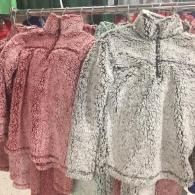 Pink and white patterned jackets hanging on a clothing rack in a store