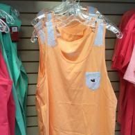 Orange sleeveless dress on a hanger, with lace shoulders and a small front pocket