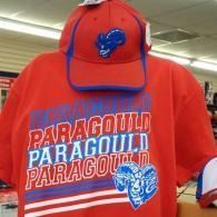 Red hoodie and cap with blue ram logos and “PARAGOULD” text hanging in a store