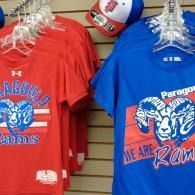 Red and blue graphic T-shirts hanging on display in a store, featuring a ram logo.