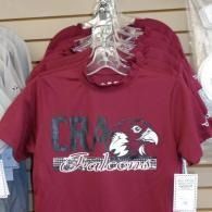 Maroon CRA Falcons T-shirt hanging on a store display rack
