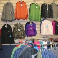 Clothing store wall with colorful jackets and tops hanging on display racks