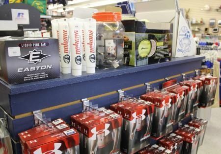 Assorted sports equipment and accessories displayed on store shelves, including red boxed items and bottles.