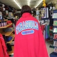 Person wrapped in a red blanket with “PARAGOULD” on the back, standing in a store aisle.