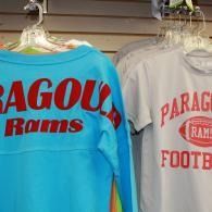 Two sports shirts on hangers, one blue and one white, with red Paragould Rams lettering.