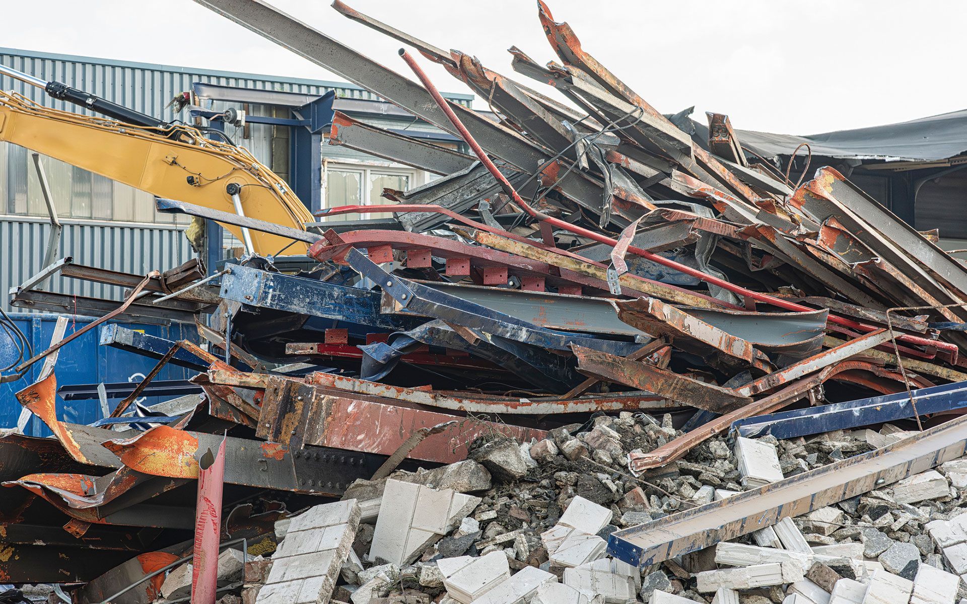 A pile of rubble is sitting in front of a building being demolished.
