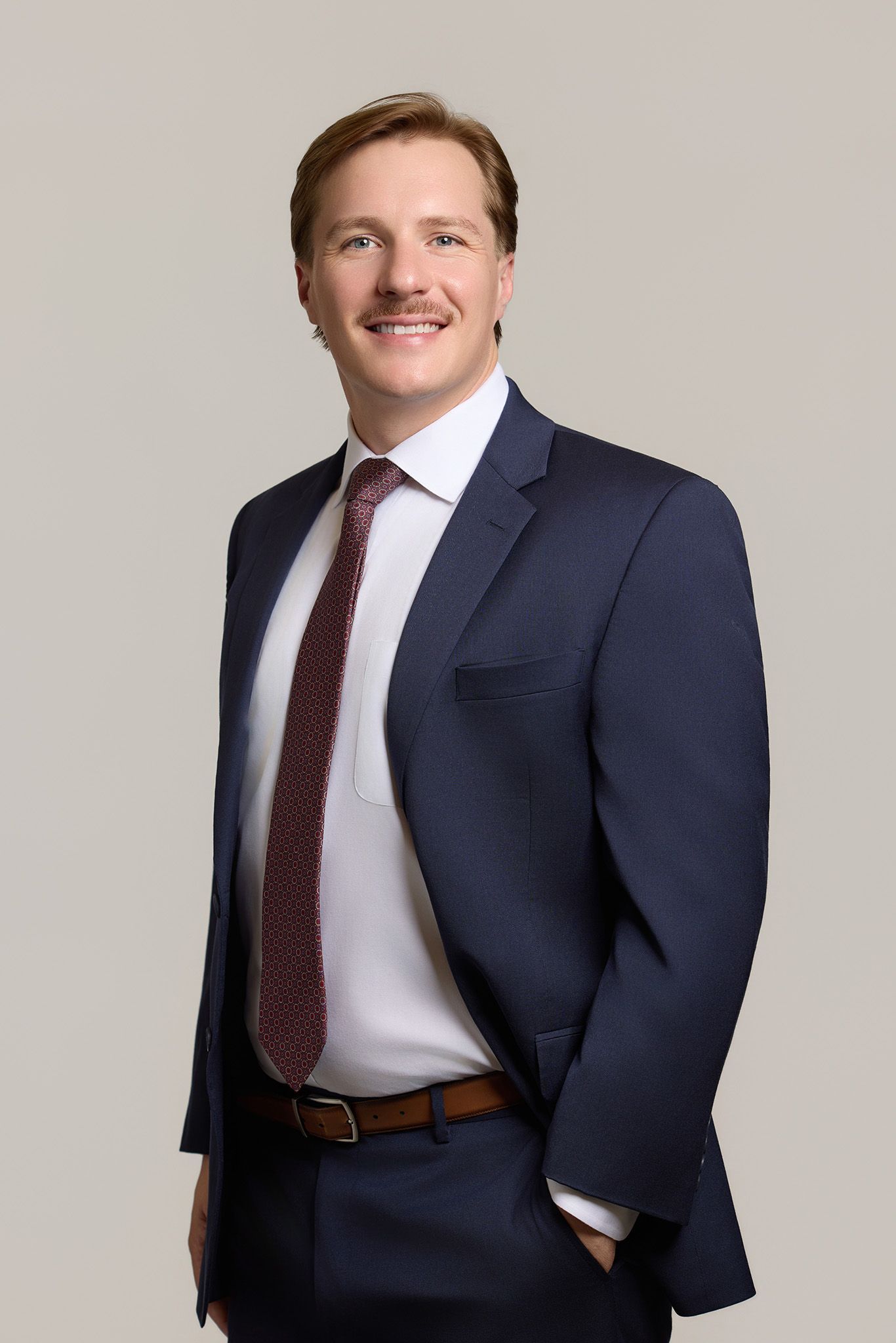 A man in a suit and tie is smiling for the camera.