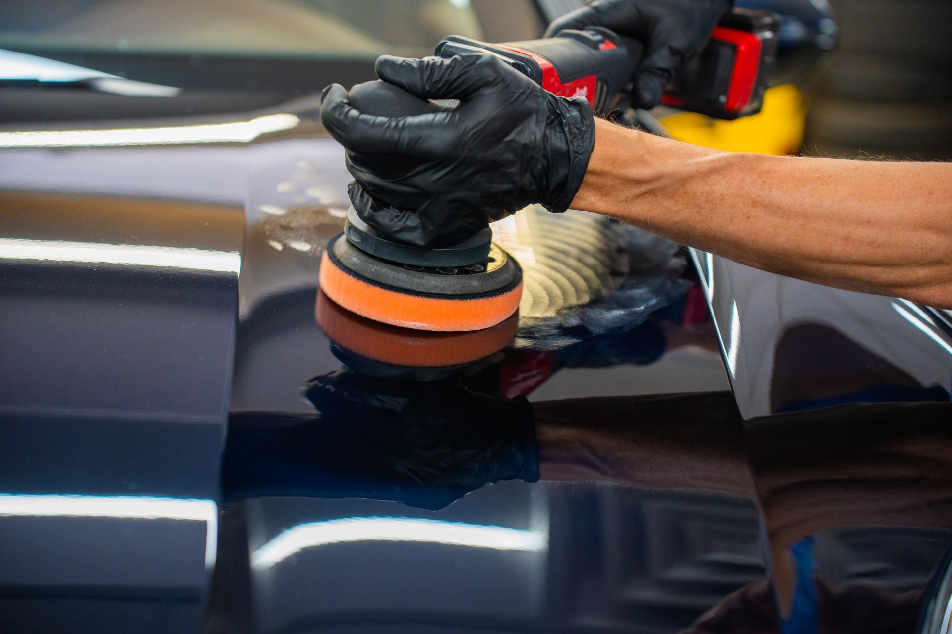 A person is polishing a car with a machine.