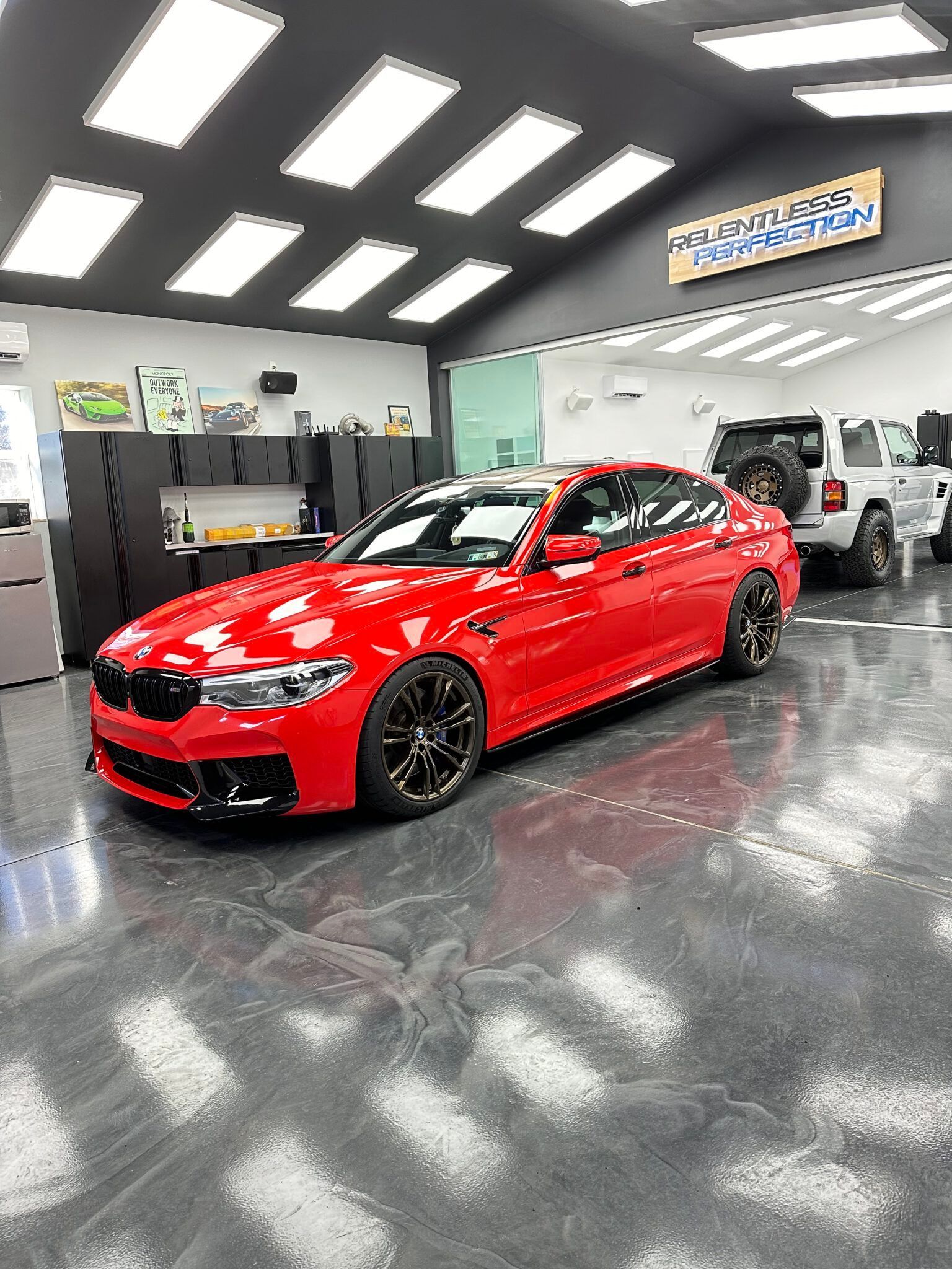 A couple of cars are parked in a garage.