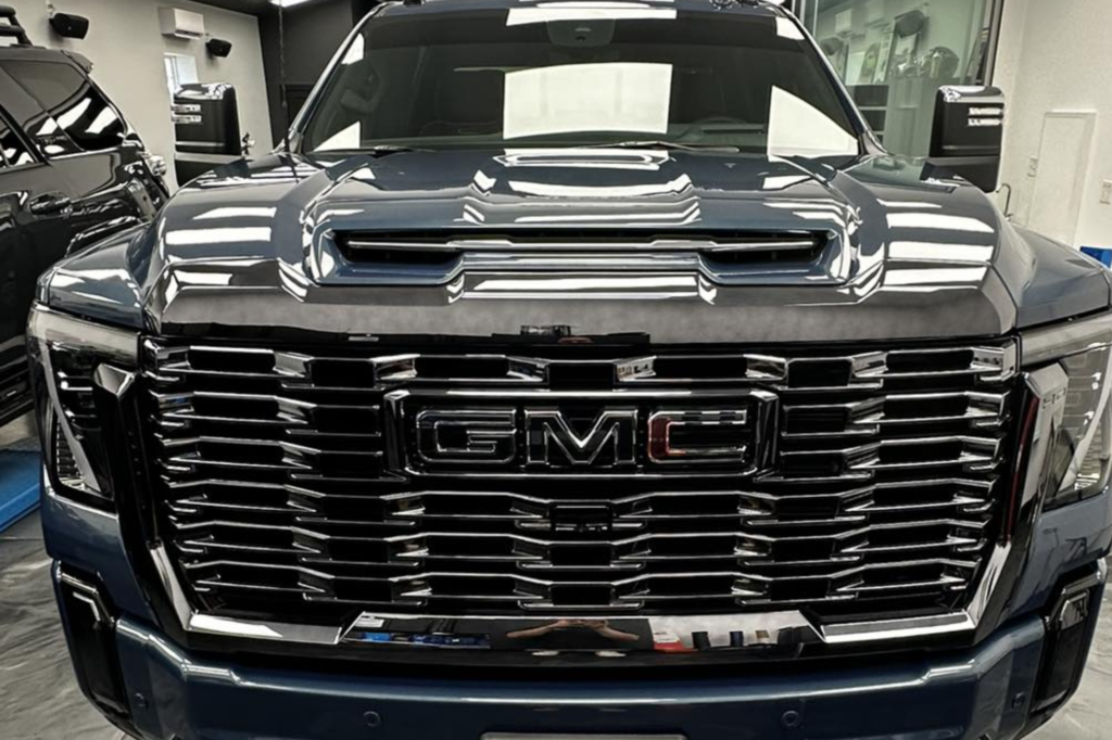A black gmc truck is parked in a garage.