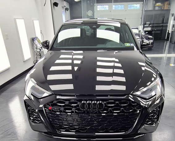 A black audi car is parked in a garage
