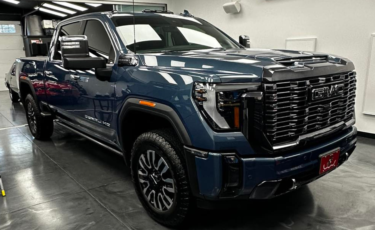 A blue pickup truck is parked in a garage.