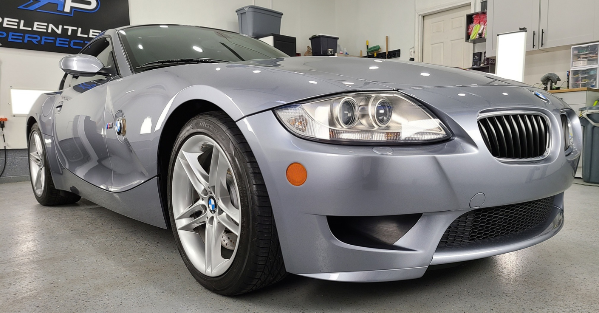 A gray bmw z4 is parked in a garage.