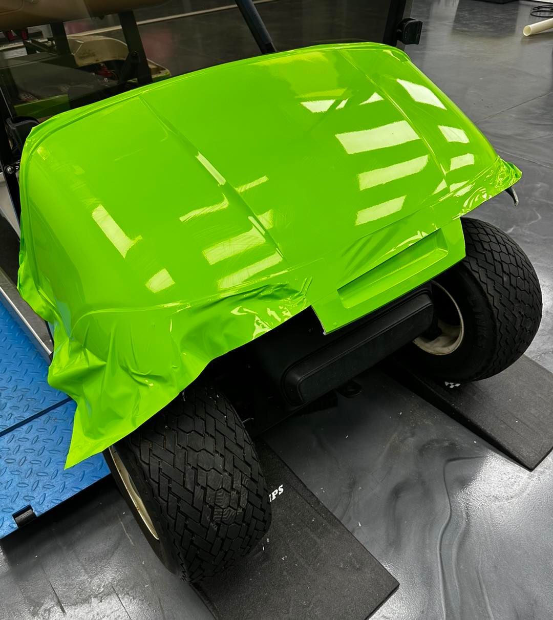 A golf cart is wrapped in neon green vinyl