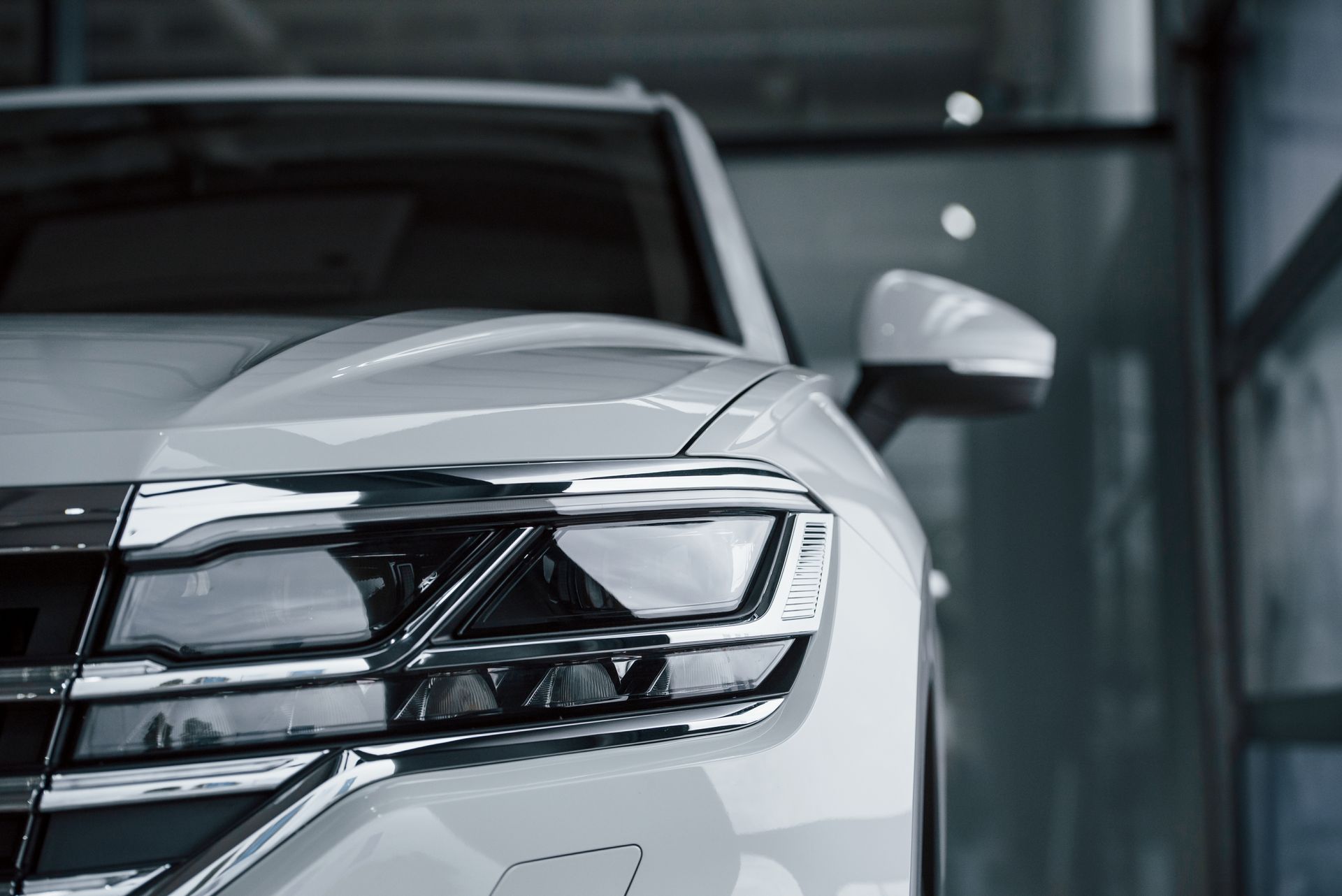 A close up of a white car parked in a showroom.