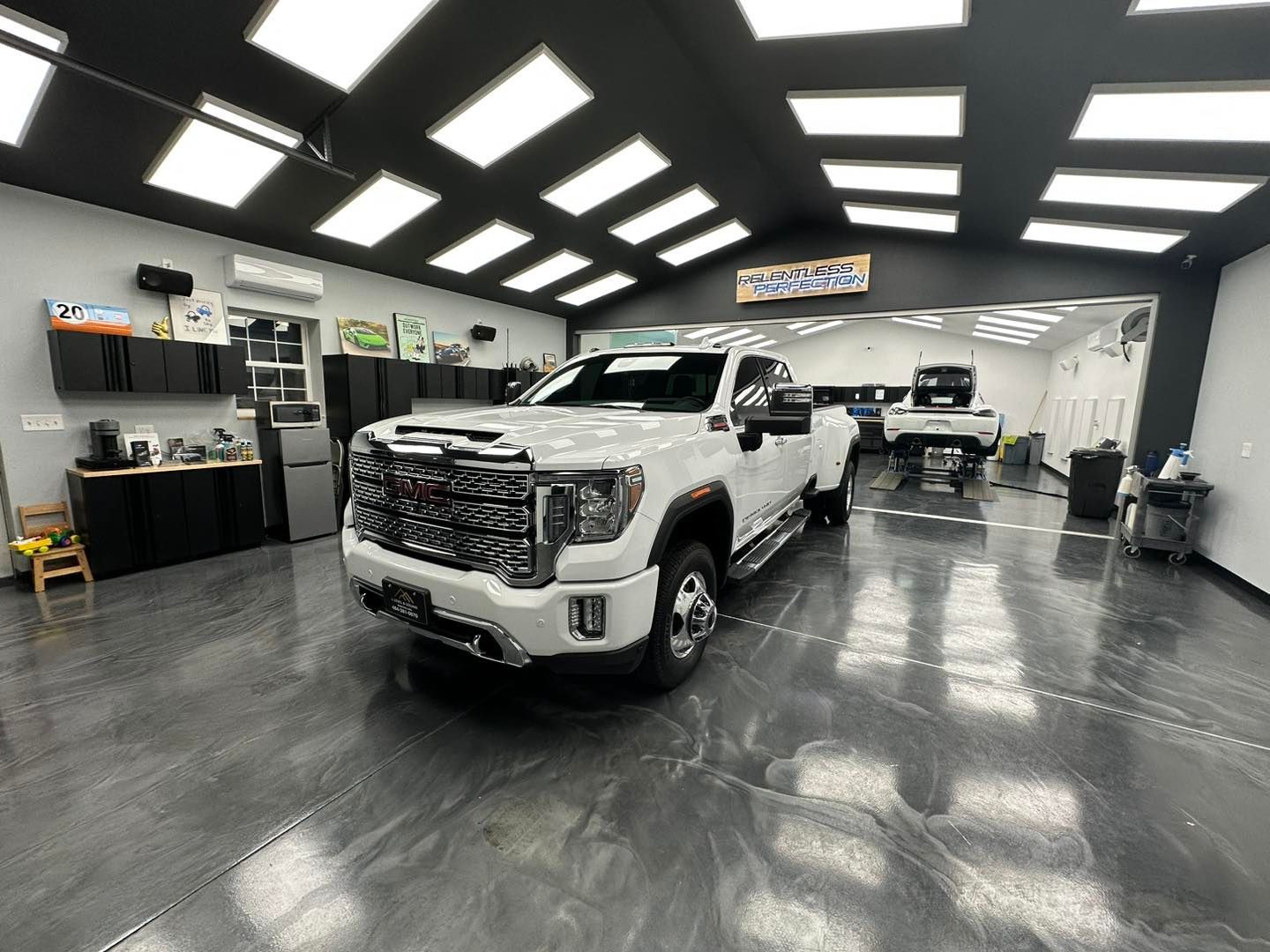 A white truck is parked in a garage.