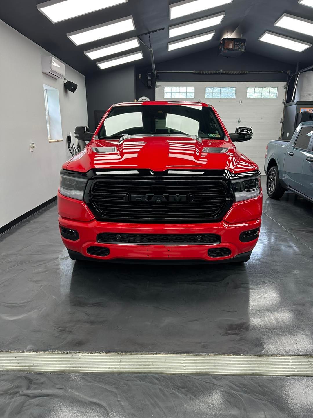 A red dodge ram 1500 is parked in a garage.