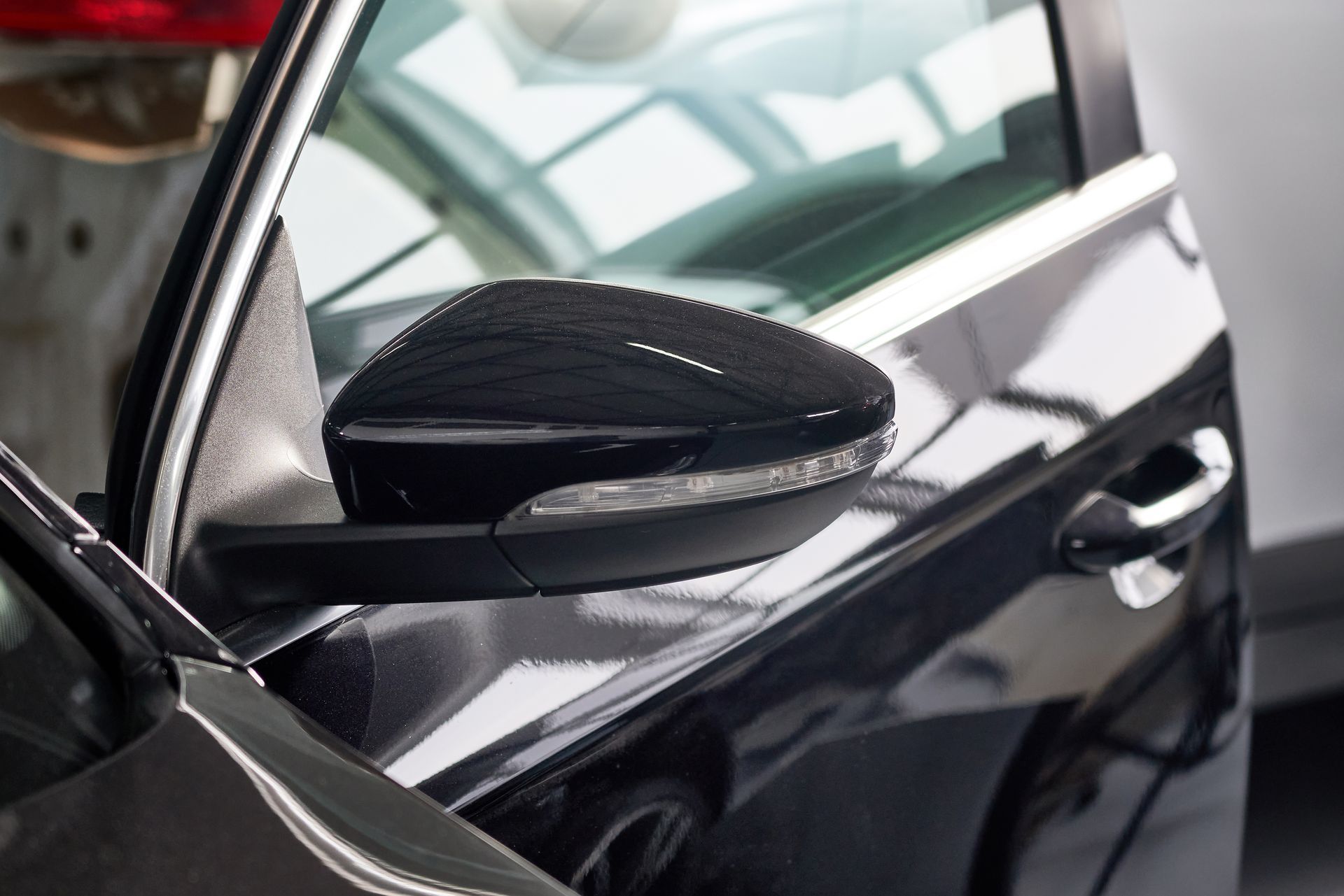 A close up of a black car 's side mirror