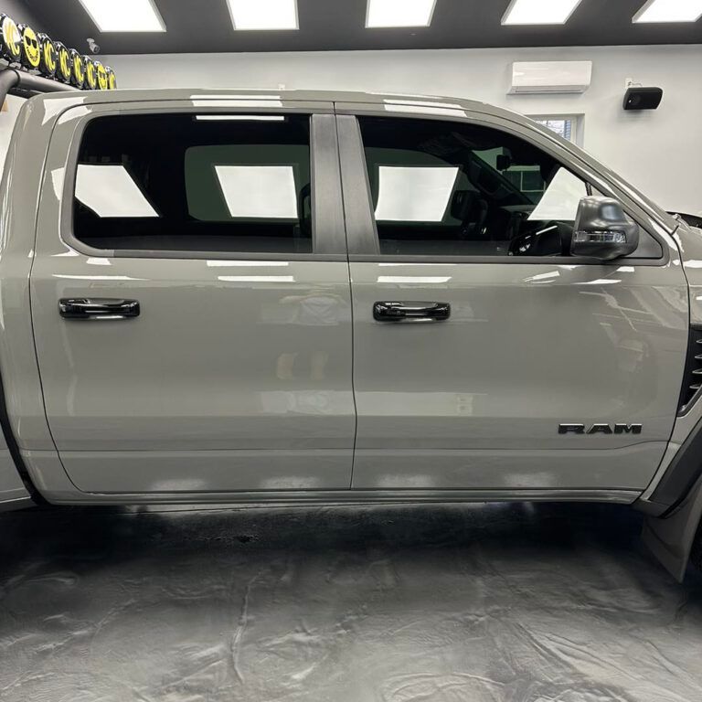 A white ram 1500 truck is parked in a garage.