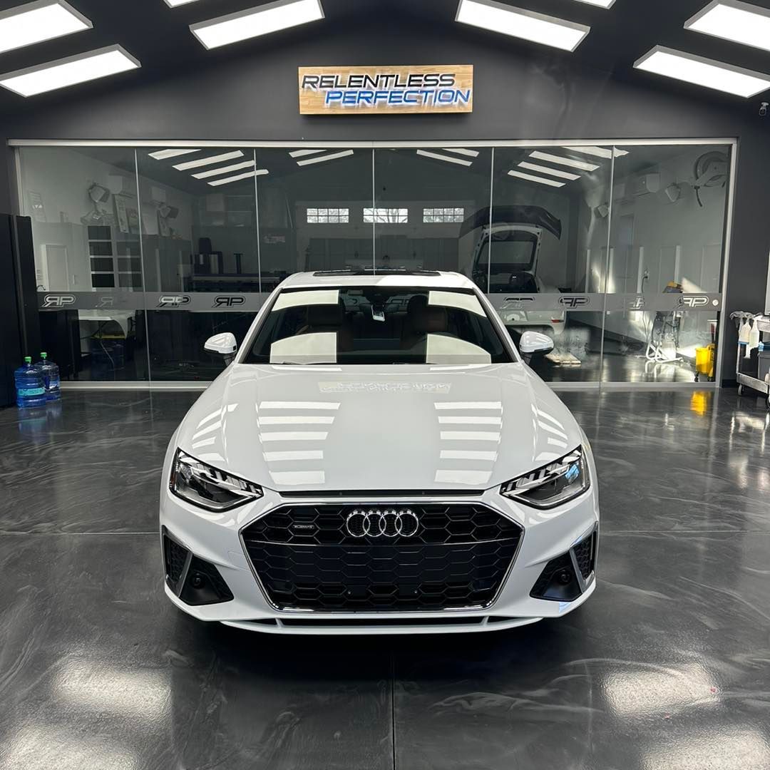 A white audi a4 is parked in a garage.