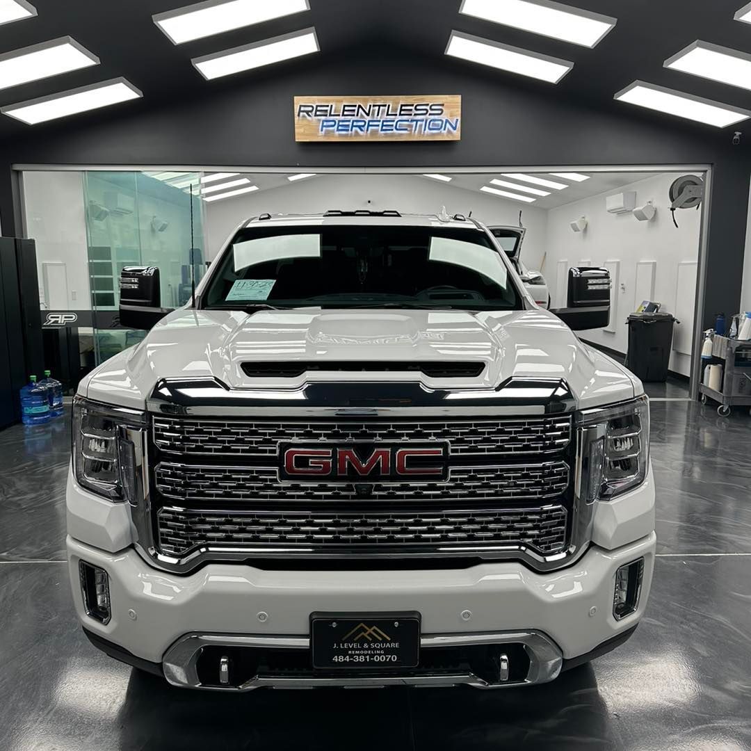 A white gmc truck is parked in a garage.