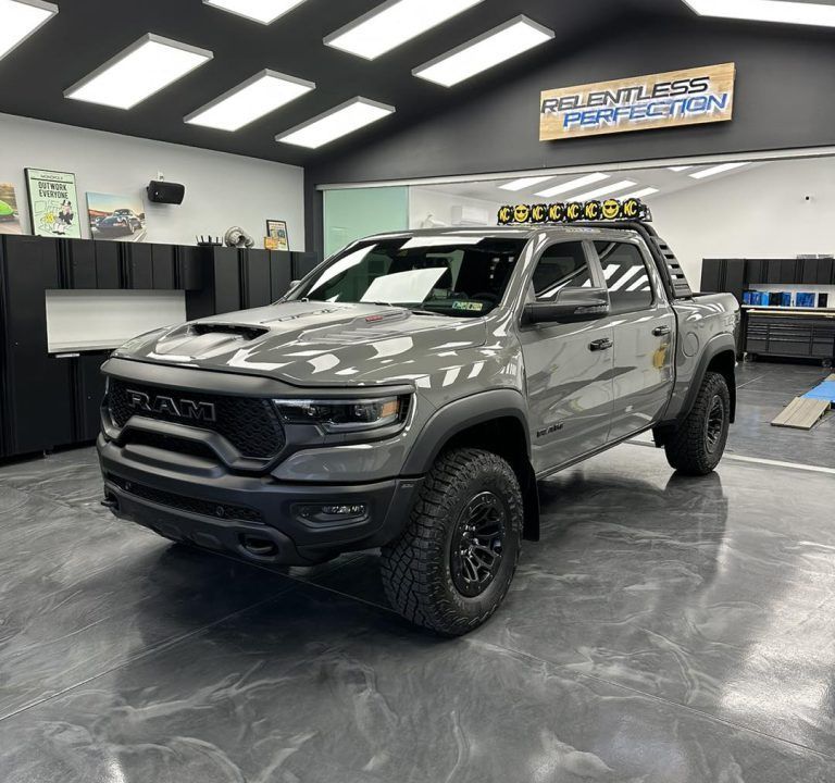 A gray ram truck is parked in a garage.
