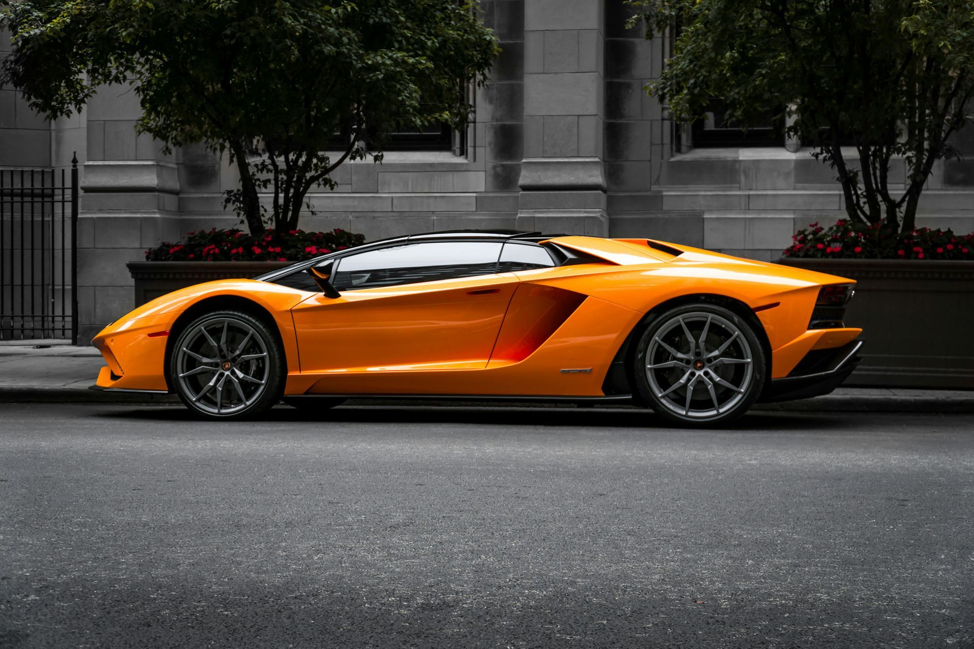 A yellow lamborghini aventador is parked on the side of the road.