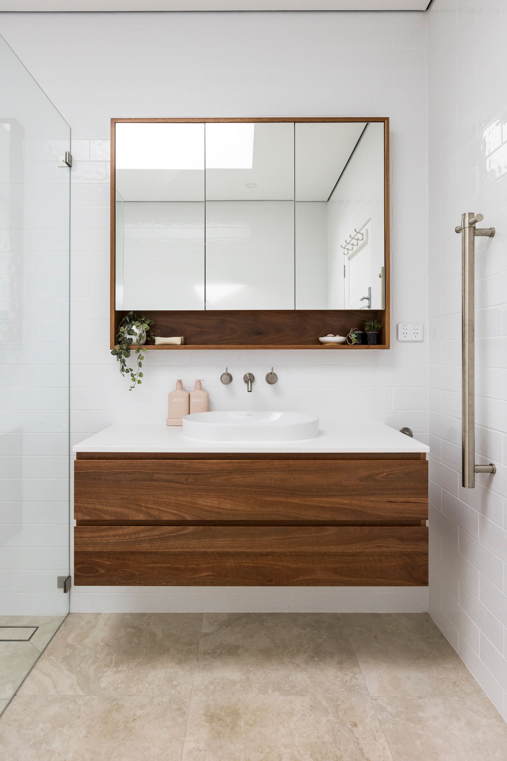 A bathroom with a sink , mirror and walk in shower. — Matt Loder Constructions in Figtree, NSW