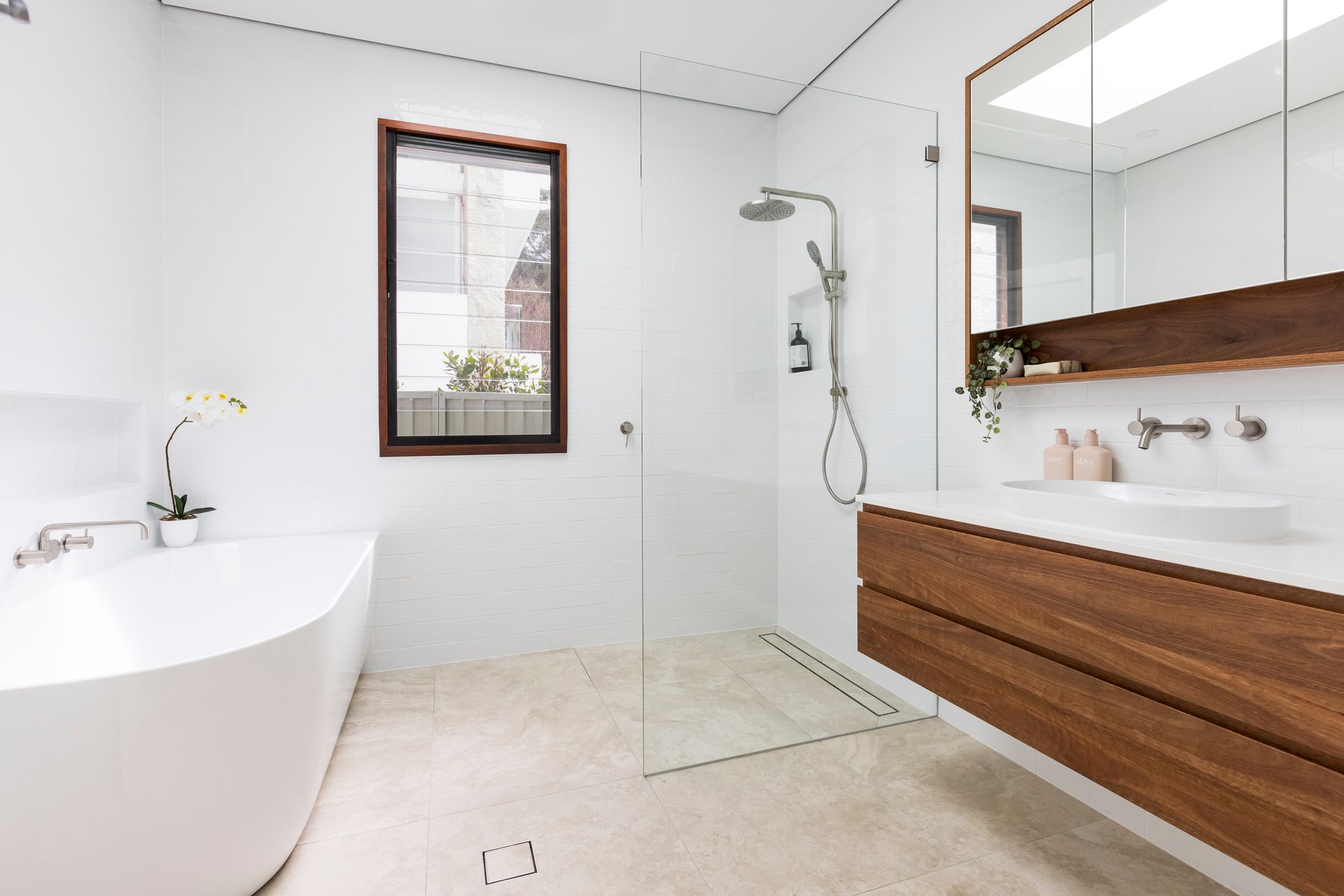 A Bathroom With a Bathtub, Sink, Shower and Mirror — Matt Loder Constructions in Bulli, NSW
