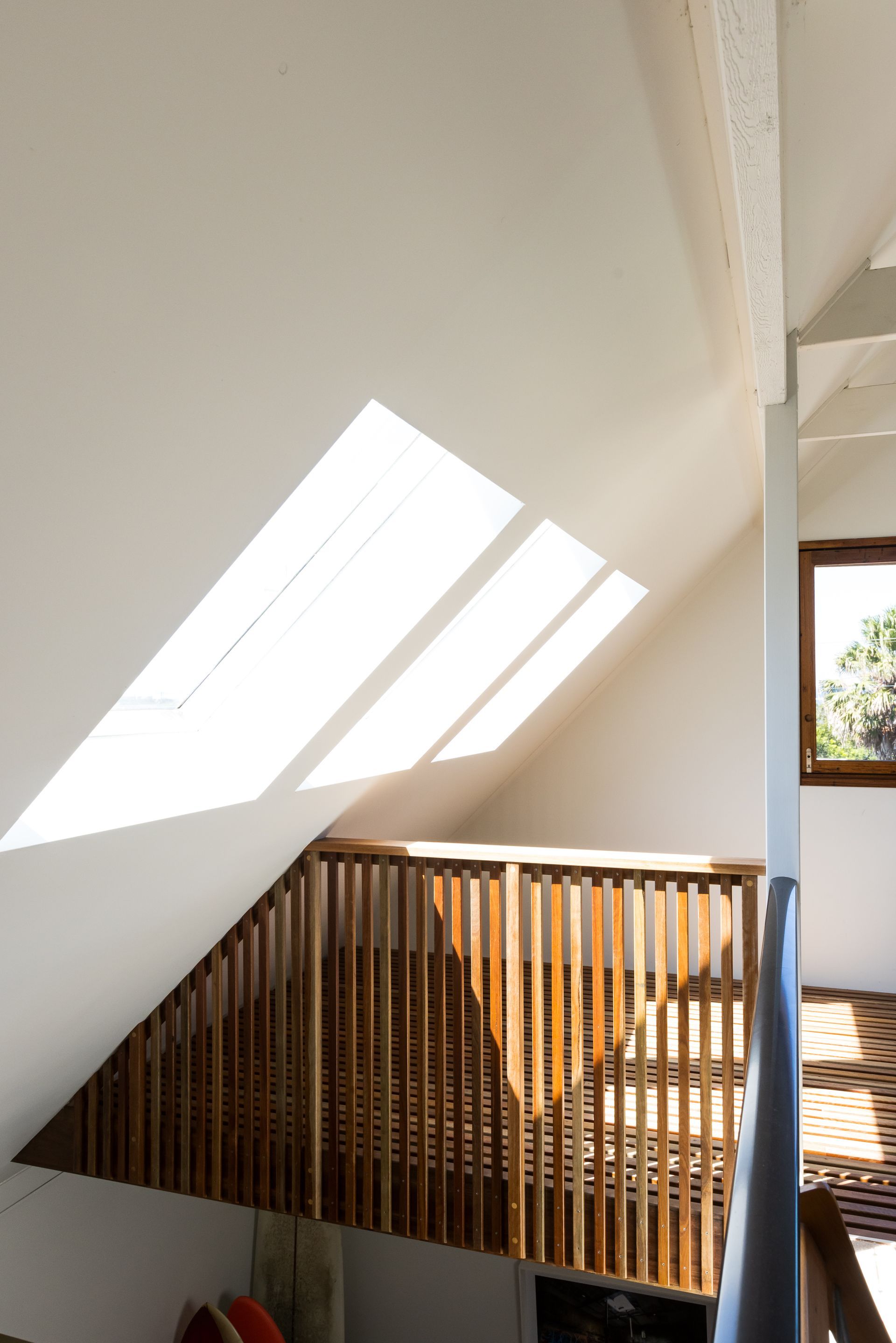 A staircase with a wooden railing and a window — Matt Loder Constructions in Figtree, NSW