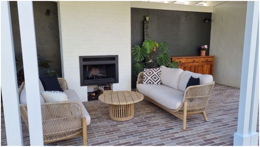 A patio with wicker furniture and a fireplace— Matt Loder Constructions in Bulli, NSW