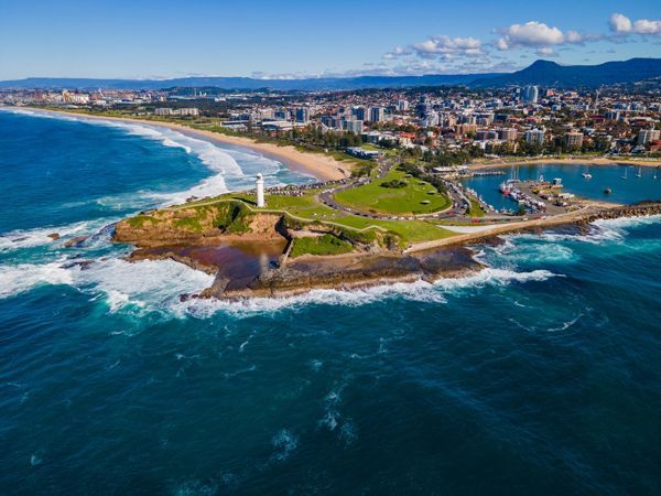 An Aerial View of a Small Island in the Middle of the Ocean With a Lighthouse — Matt Loder Constructions in Wollongong, NSW