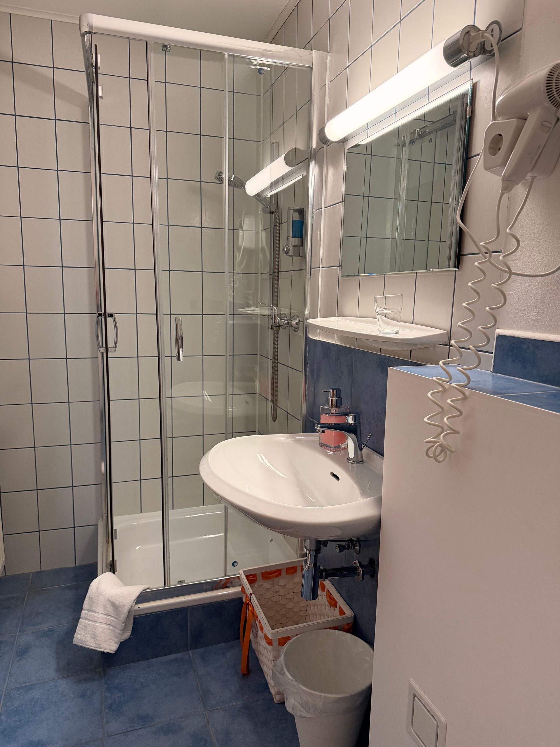 helles Badezimmer verfliest, mit großer Dusche.
