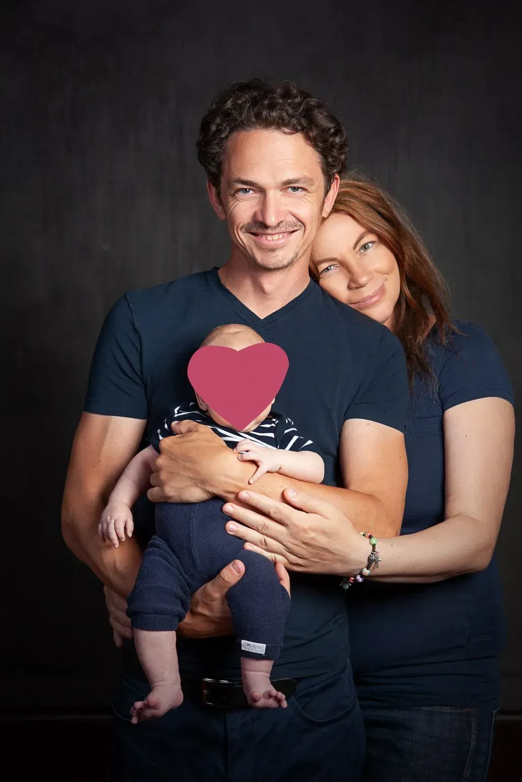 Familienfoto von Frau und Herr Geisler mit Kleinkind im Arm.
