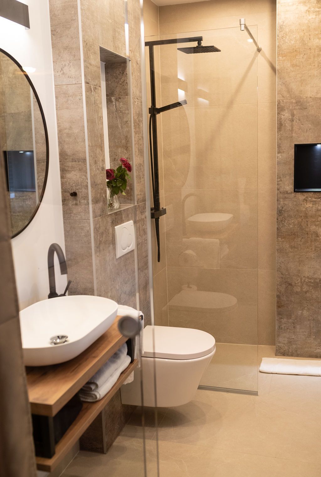 Doppelzimmer neue renovierte Dusche mit naturstein und glaswand, dazu schwarze armaturen und warme beläuchtung