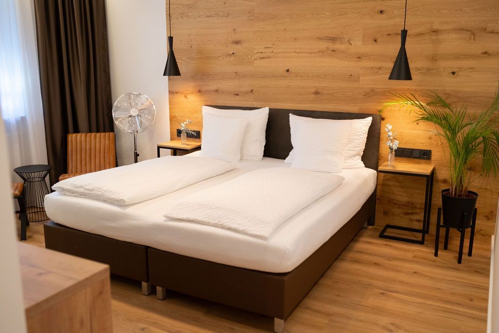 Eiche Industrial Doppelzimmer. Großes Doppelbett an holzverkleideten Wand. Warme Beläuchtung