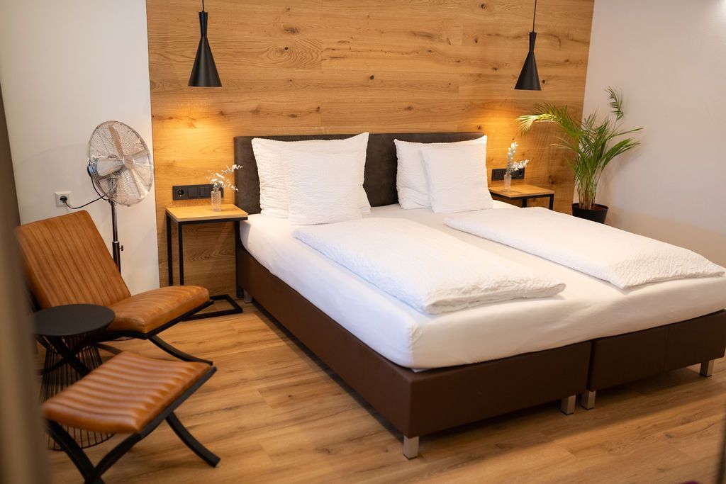 Eiche Industrial Doppelzimmer. großes Doppelbett an Holzverkleideten Wand. mit warmer Beläuchtung