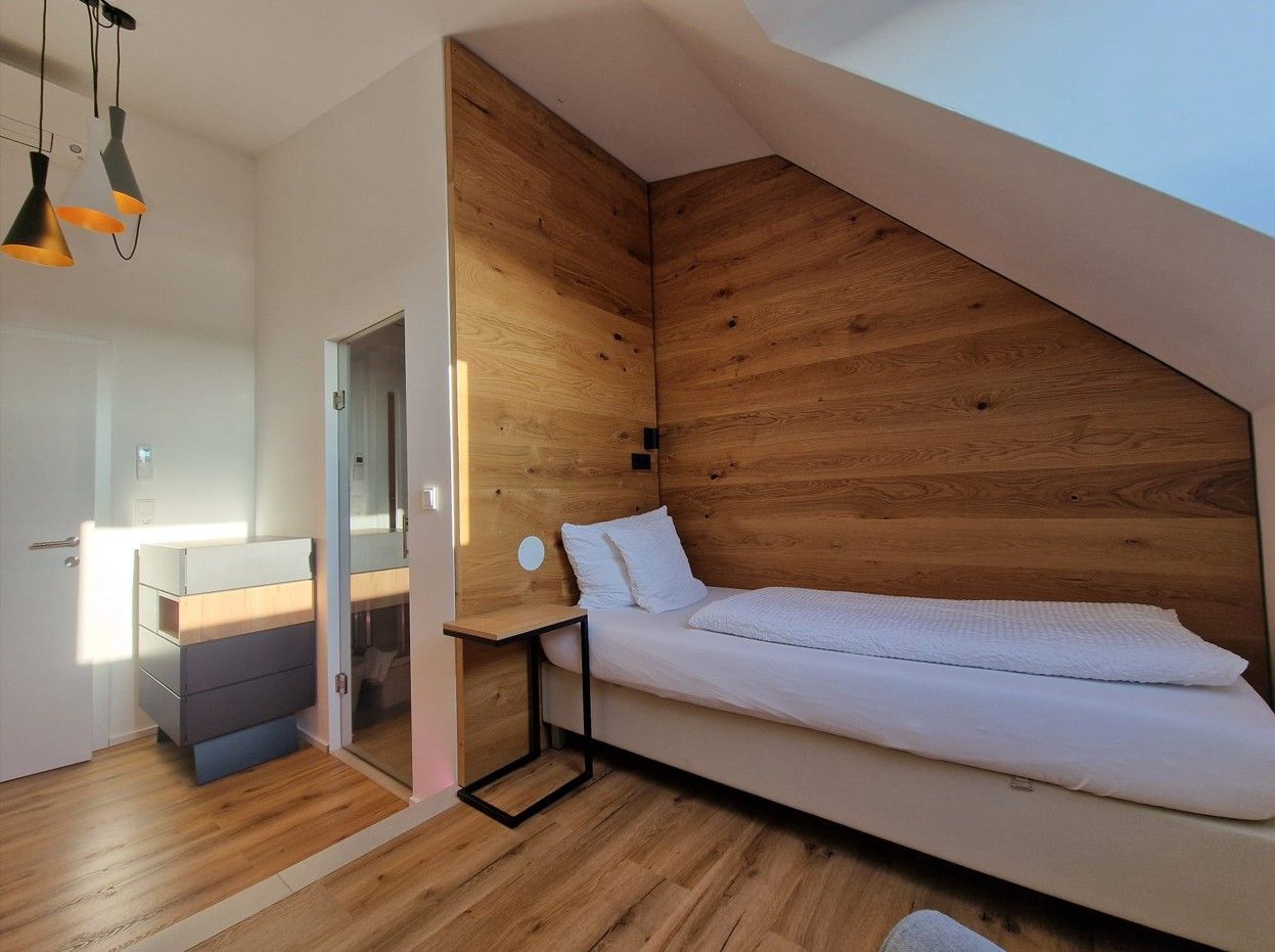Roof top Einzelzimmer. Bett an holzverkleideten Wand. Warme Beläuchtung