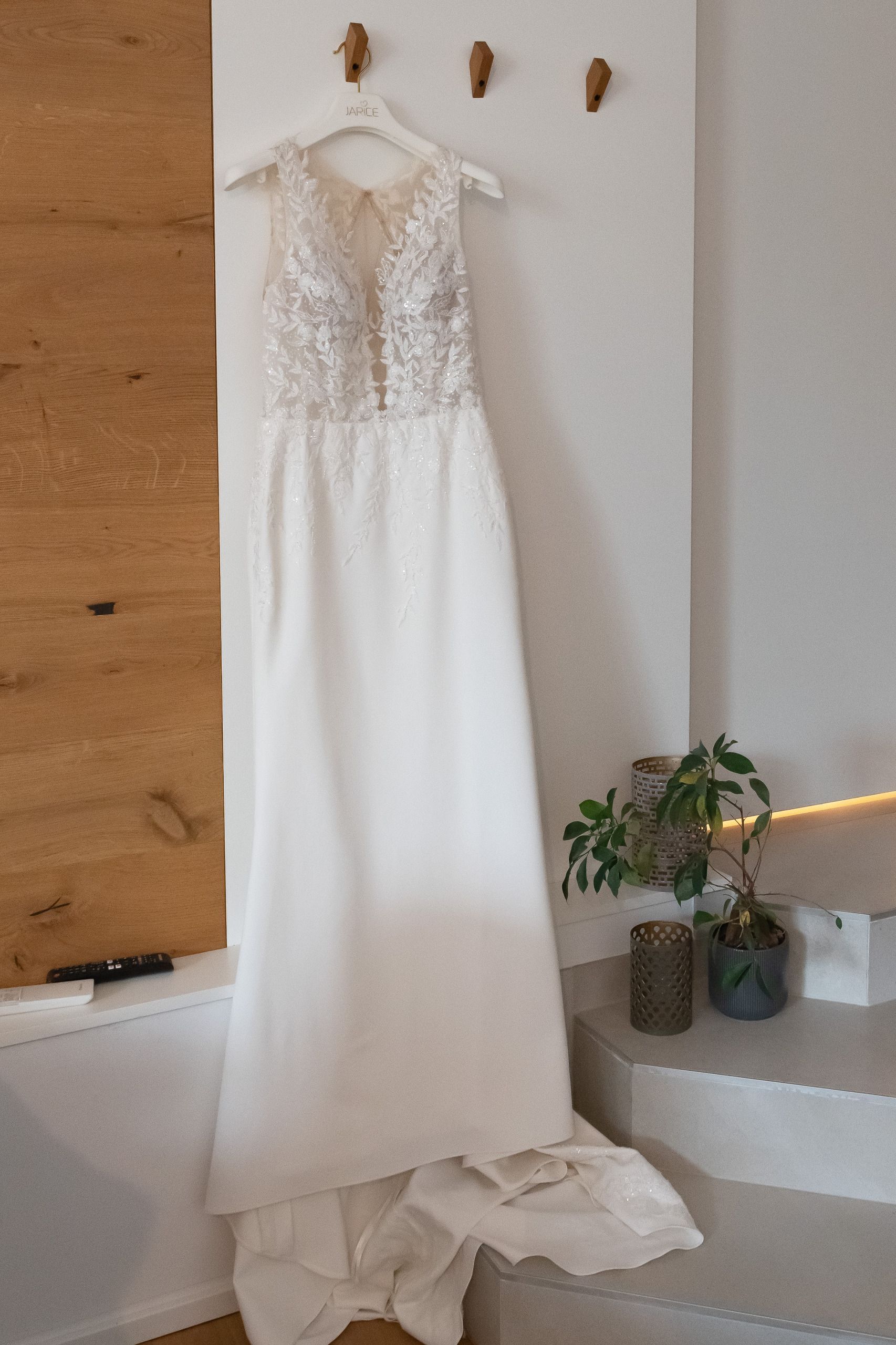 weißes Hochzeitskleid mit Perlen verziert. Kleid hängt noch am Kleiderbügel.