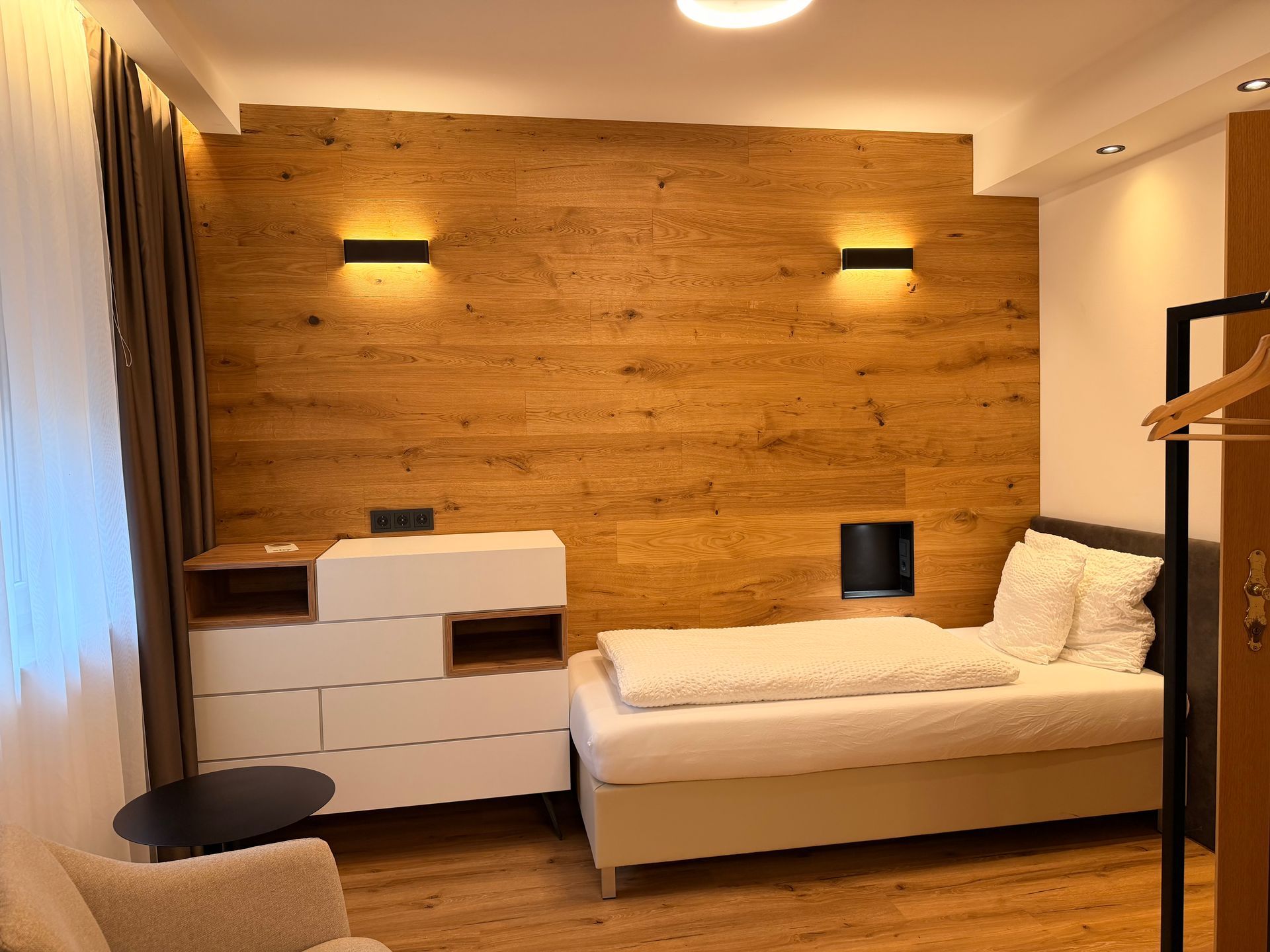 offene Glasdusche mit Naturstein und warmer Beleuchtung. 