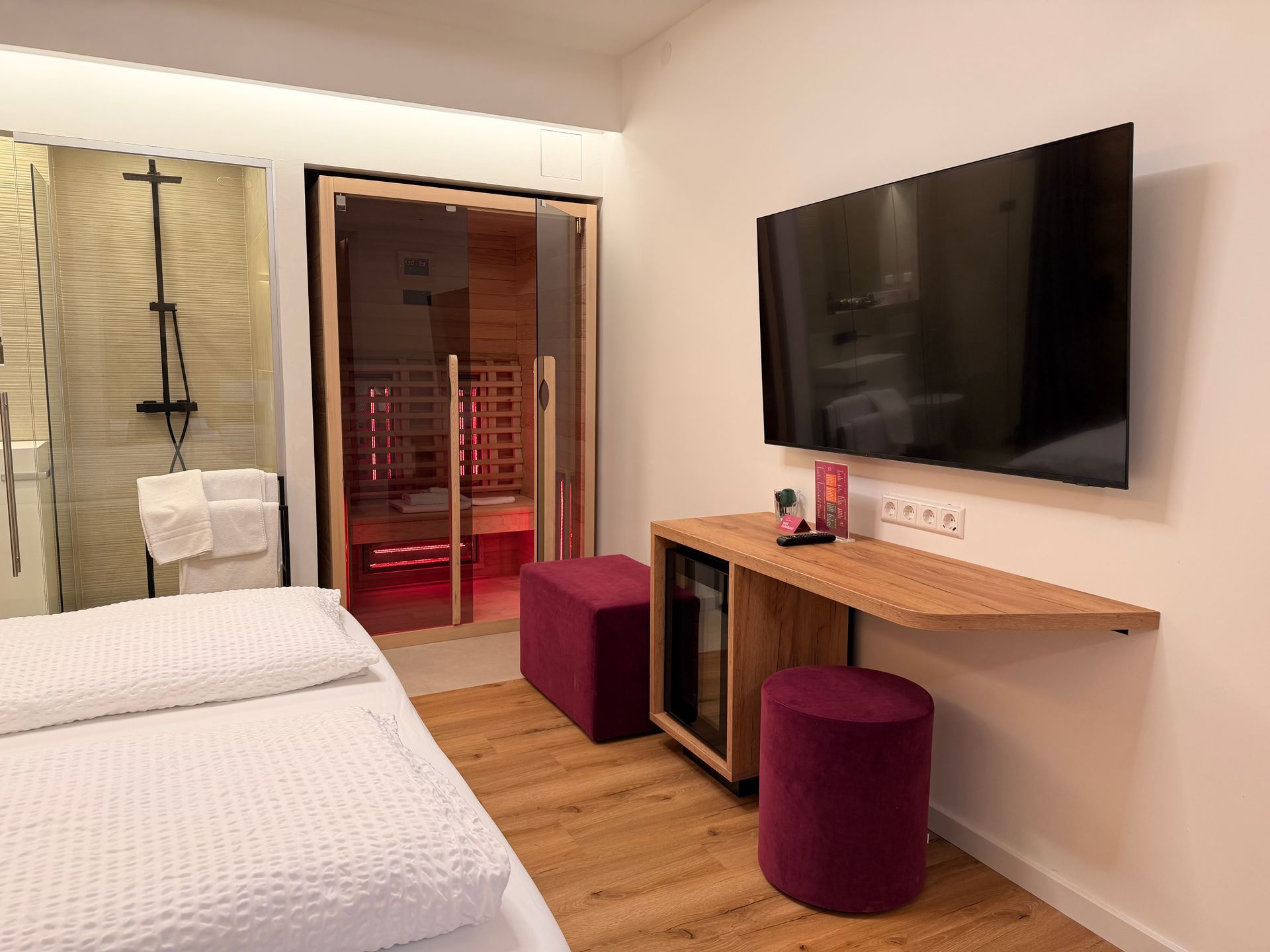 Eiche Queensize. Bett an holzverkleideten Wand. Warme Beleuchtung