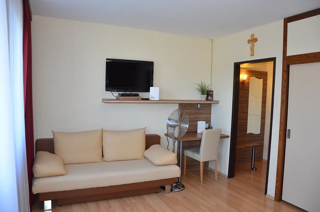 Doppelzimmer mit Schlafsofa und daneben ein Schreibtisch.