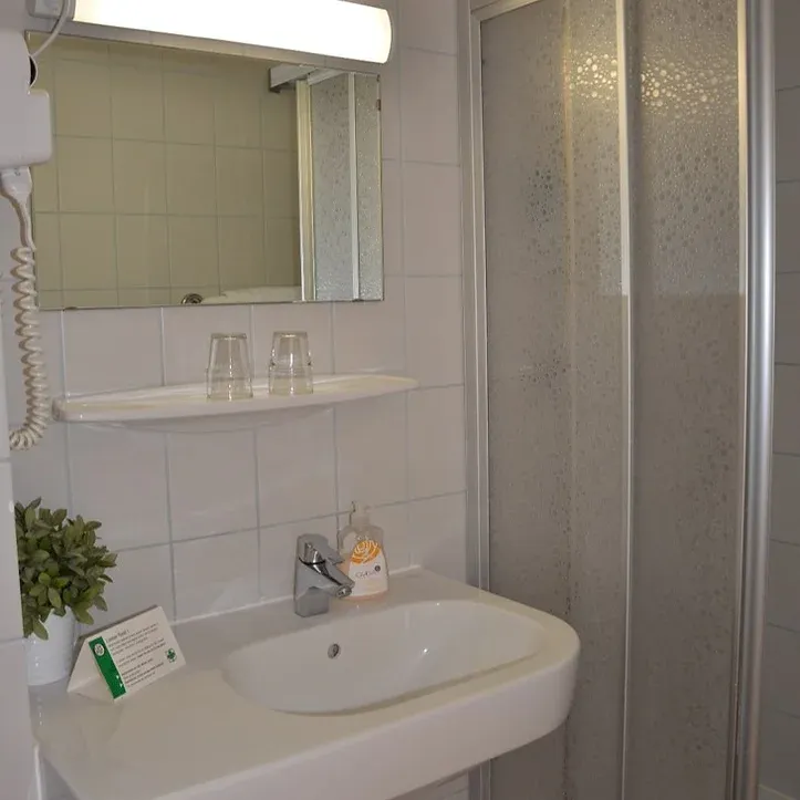 helles Badezimmer verfliest, mit großer Dusche.