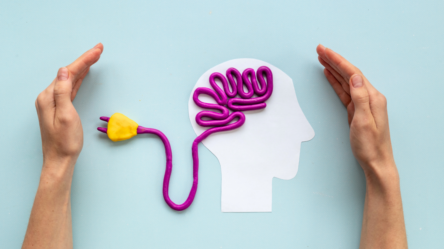 Hands framing a white head silhouette with a purple tangled cord and yellow plug on a blue background