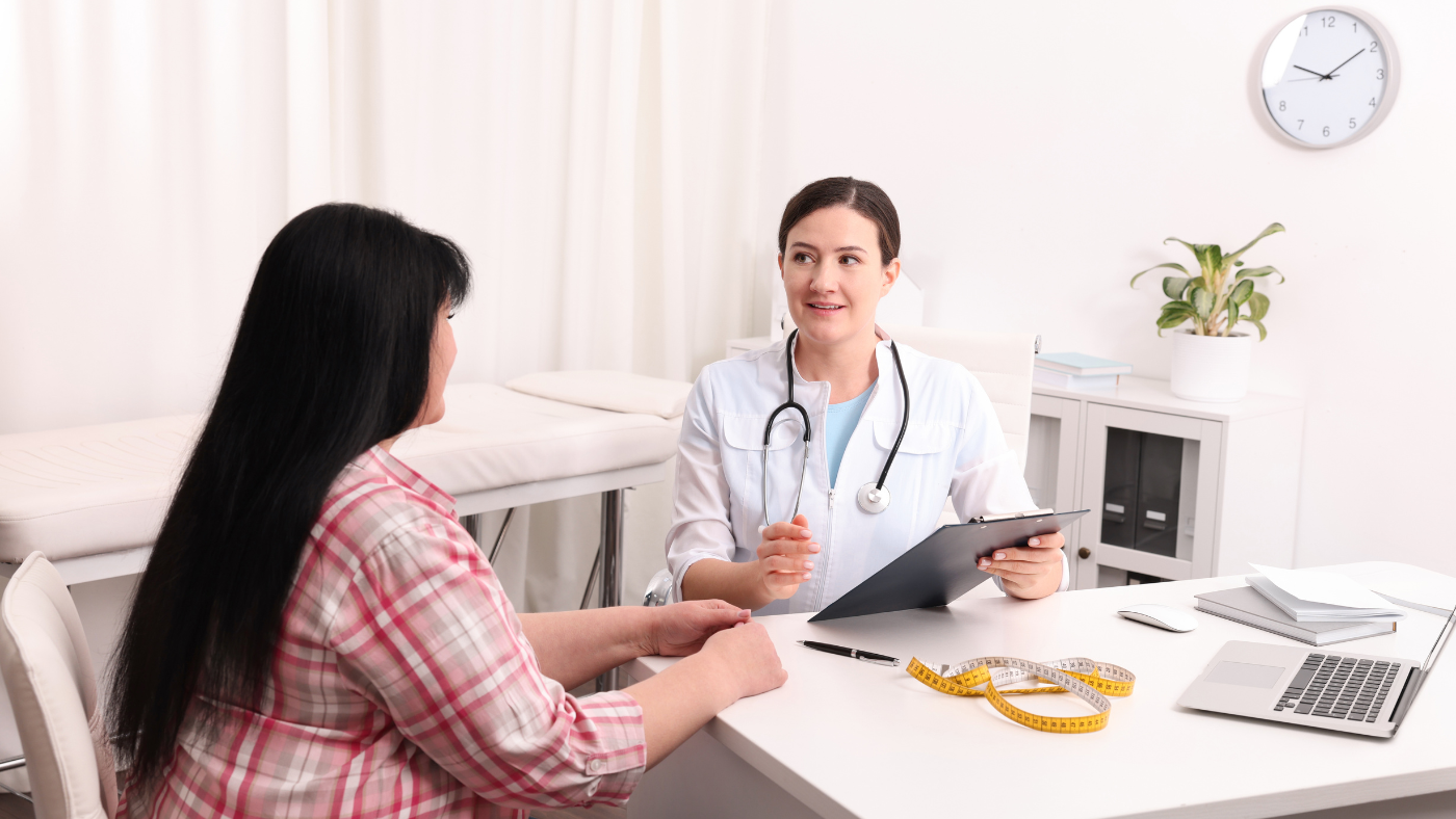Doctor consulting with a patient at a desk in a bright clinic office