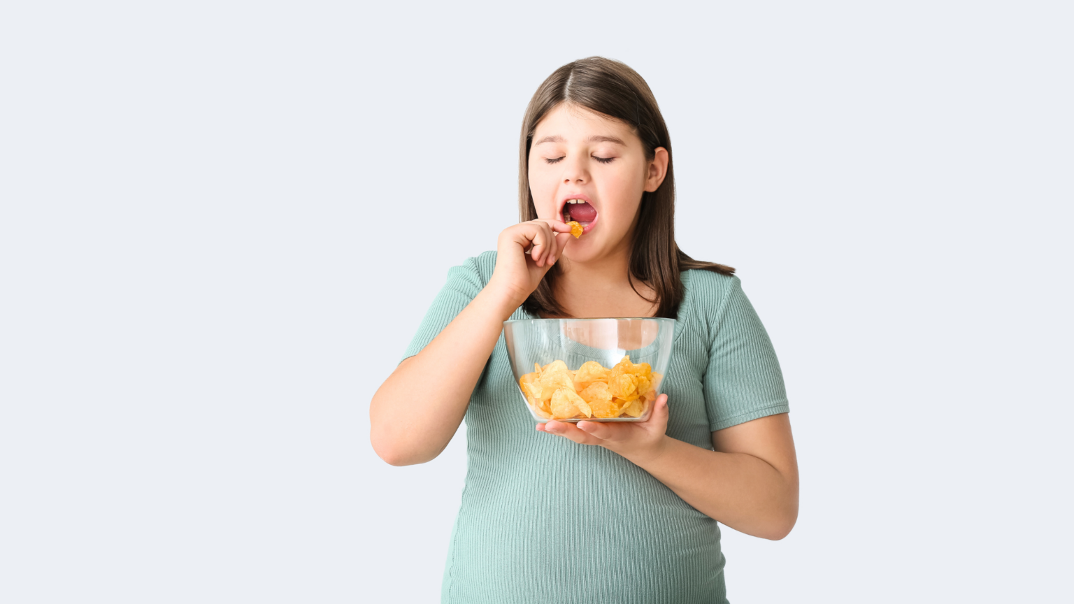 Woman eating fruit from a clear container against a light background