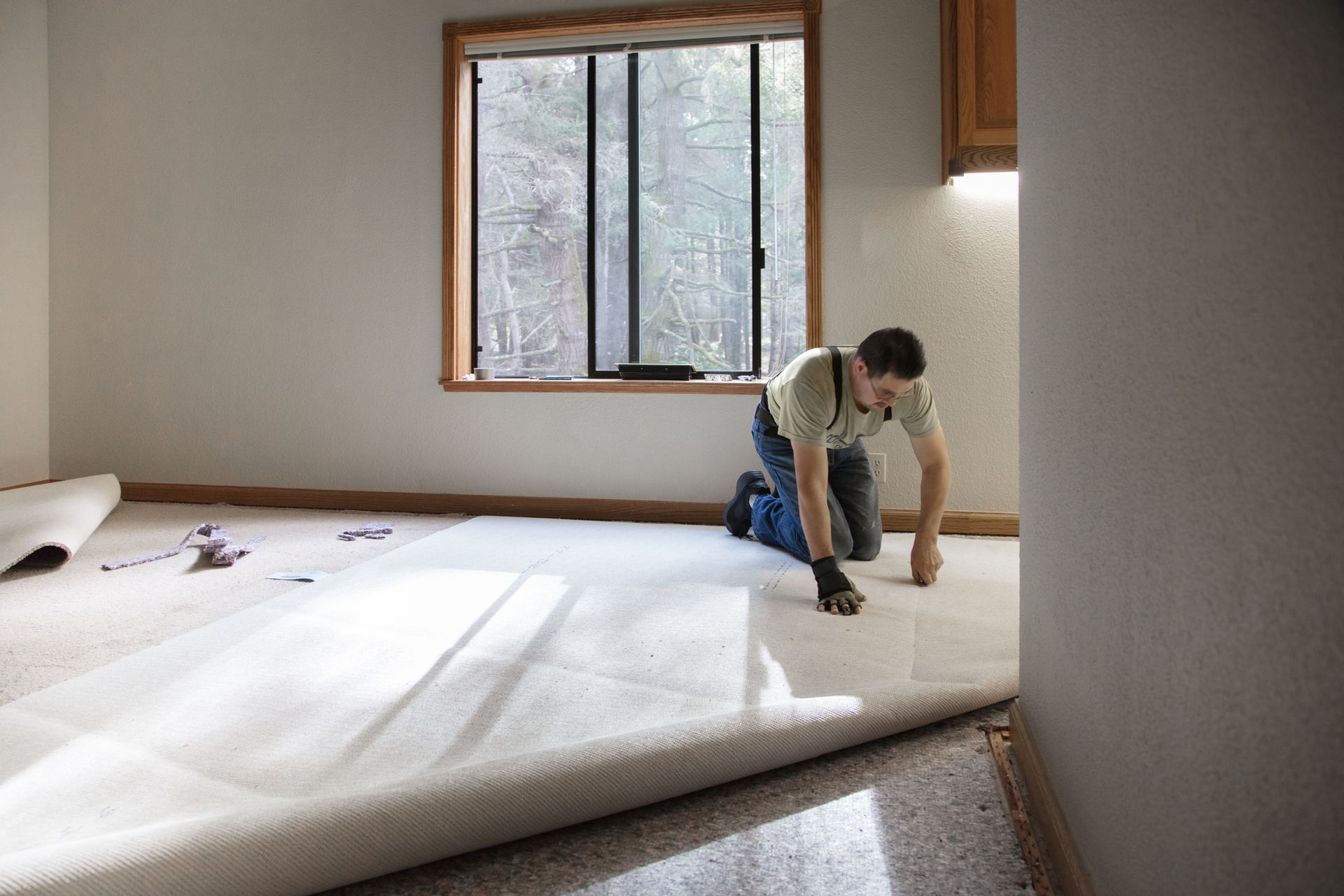 A man is kneeling on the floor in a room. A man is kneeling on the floor in a room.