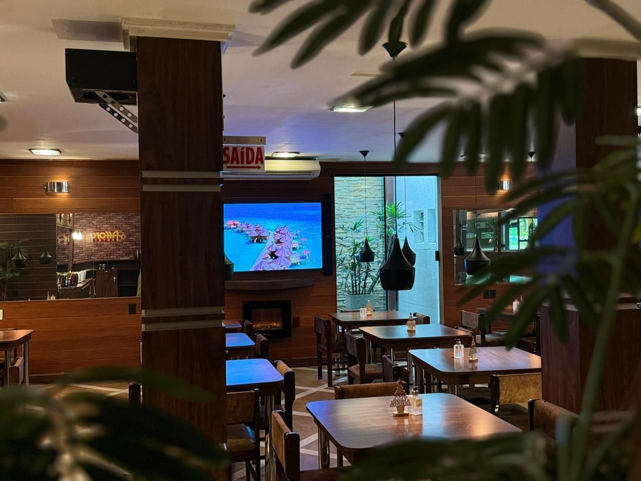Um restaurante com mesas e cadeiras e uma placa que diz saida