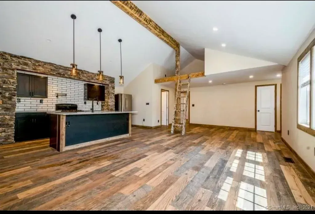 An empty house with wooden floors and a kitchen